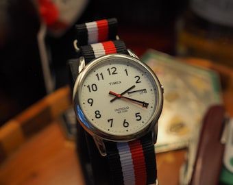 Zegarek Timex Weekender | Biała tarcza, srebrna koperta, pasek NATO w paski z datą i dniem tygodnia