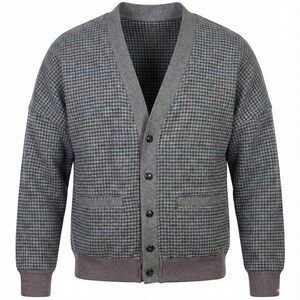 Op de afbeelding: Een grijze cardigan met een pied-de-poule patroon in grijstinten, blauw en bruin. De trui heeft een V-hals, grijze afwerking en een knoopsluiting. Het heeft twee voorzakken en geribde manchetten en zoom.