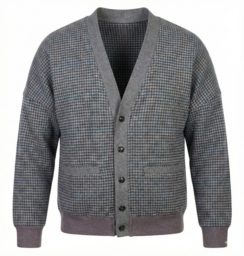 Op de afbeelding: Een grijze cardigan met een pied-de-poule patroon in grijstinten, blauw en bruin. De trui heeft een V-hals, grijze afwerking en een knoopsluiting. Het heeft twee voorzakken en geribde manchetten en zoom.