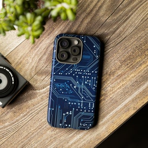 May include: A navy blue smartphone case with a circuit board pattern in blue and white. The case has a glossy finish and a camera aperture. The phone case is on a wooden surface.