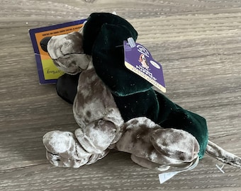 May include: A plush dog toy with a green and gray color scheme. The dog has a dark green head and ears, with gray body and legs. The toy has a tag that reads "Hush Puppies Edition Beanie Babies".