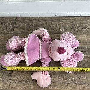 Peut inclure: Une peluche rose avec un visage souriant, de grandes oreilles et une robe. Le jouet mesure environ 46 cm de long, mesur&eacute; avec un m&egrave;tre ruban jaune. Le jouet a un corps rose clair avec des accents roses plus fonc&eacute;s.