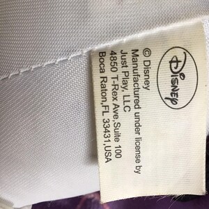 May include: White tag with black text stating "Disney &copy;Disney Manufactured under license by Just Play, LLC 4850 T-Rex Ave, Suite 100 Boca Raton, FL 33431, USA"