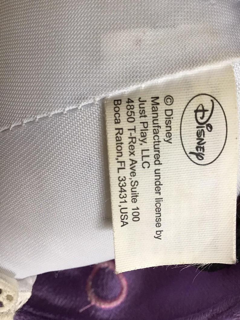 May include: White tag with black text stating "Disney &copy;Disney Manufactured under license by Just Play, LLC 4850 T-Rex Ave, Suite 100 Boca Raton, FL 33431, USA"
