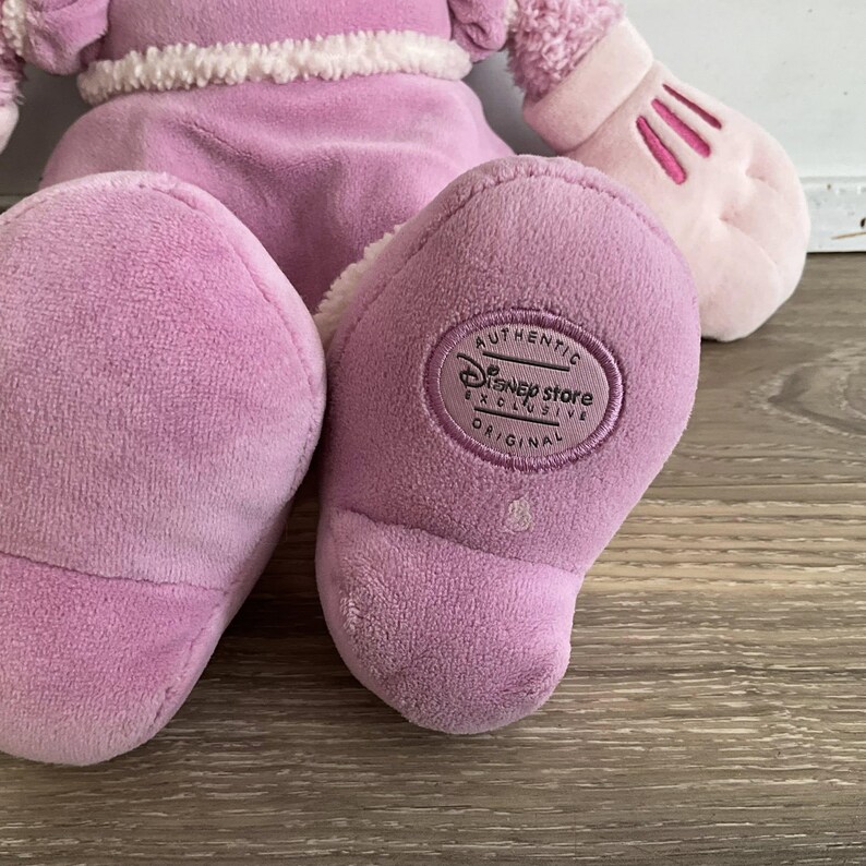 Peut inclure: Une poup&eacute;e en peluche rose, avec une mitaine rose clair. Le pied de la poup&eacute;e porte une &eacute;tiquette Disney Store Exclusive Original. La poup&eacute;e est faite d'une mati&egrave;re douce et duveteuse.