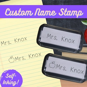 May include: Two self-inking name stamps with the name "Mrs. Knox" on them. One stamp has an apple icon and the other does not.