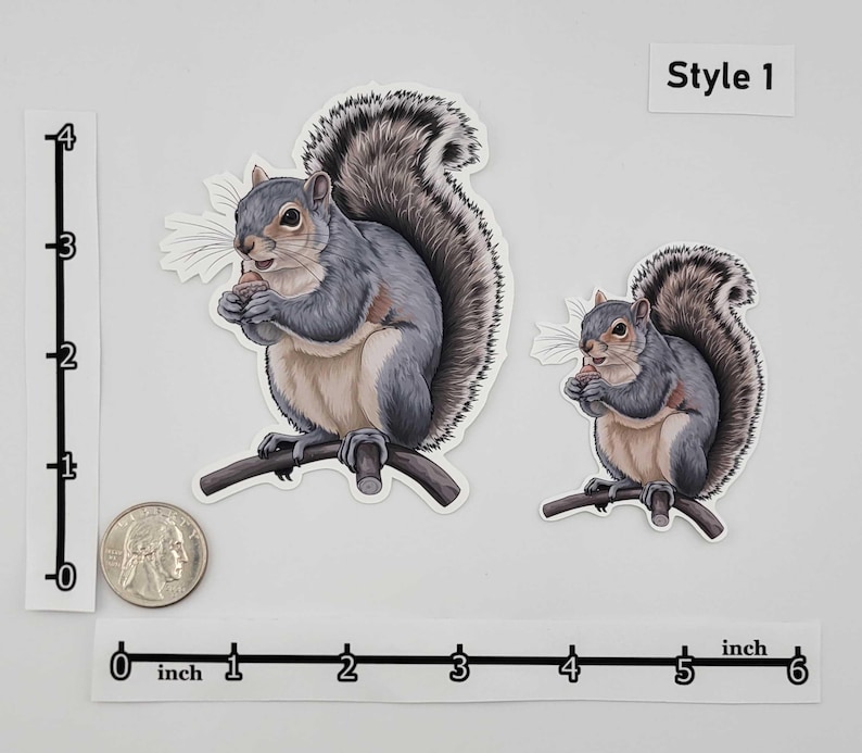 May include: Two squirrel stickers, one large and one small, both perched on a branch and holding a nut. The squirrels have gray fur and fluffy tails. The text "Style 1" is in the upper right corner.