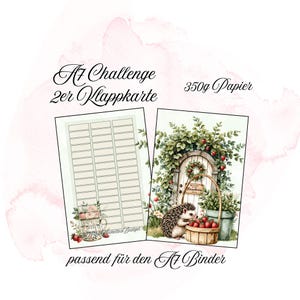 Könnte beinhalten: Zwei A7-Challenge-Karten. Eine Karte hat ein Raster aus rechteckigen Kästchen. Die andere Karte zeigt eine Aquarellillustration einer Tür mit einem Erdbeer-Kranz, einem Korb mit Erdbeeren und einem Igel. Text enthält "A7 Challenge 2er Klappkarte" und "350g Papier".