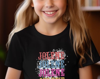 Op de afbeelding: Een zwart T-shirt met een wit splatterontwerp en het woord "Jolene" vier keer herhaald in verschillende kleuren.