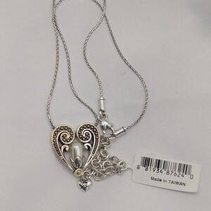 May include: A white ceramic mug with a black handle and the text "But First, Coffee" in a black, handwritten-style font. The mug is on a white surface.