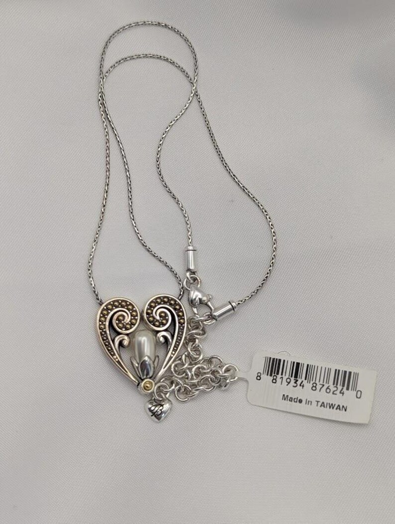 May include: A white ceramic mug with a black handle and the text "But First, Coffee" in a black, handwritten-style font. The mug is on a white surface.