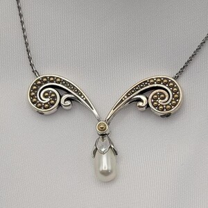 May include: A white ceramic mug with a black handle and the text "But First, Coffee" in a black, handwritten-style font. The mug is on a white surface.