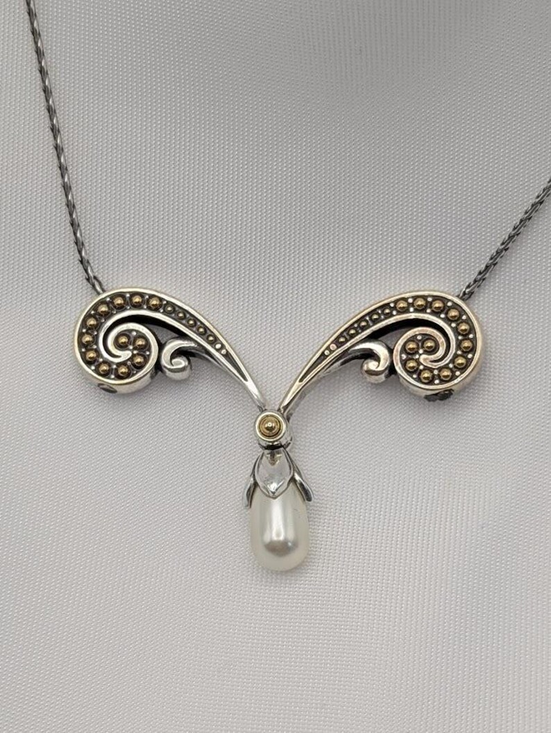 May include: A white ceramic mug with a black handle and the text "But First, Coffee" in a black, handwritten-style font. The mug is on a white surface.