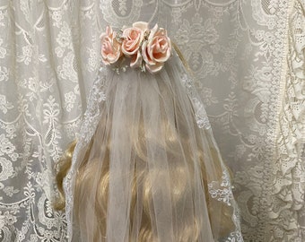 Elegant white bridal veil with beautiful lace edges. Blush colored satin roses and baby's breath on a comb.