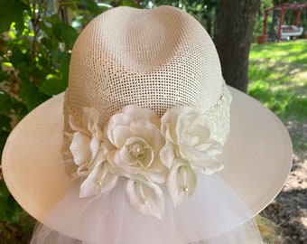 Beautiful White Fedora Wedding Hat. Accented with Roses and Lilies. Long Veil Accented with Lace. Wide Band made of Sequences. Made in Texas