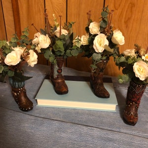 Flower arrangement in brown resin boot with look of tooled leather and brown fringe, White Rose arrangement.  Large quantities available