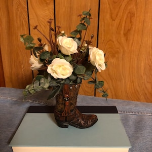 Flower arrangement in brown resin boot with look of tooled leather and brown fringe, White Rose arrangement.  Large quantities available