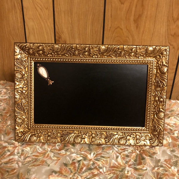 Elegant small gold framed chalkboard easel with a small pendant in the corner. Chalk included. Perfect for small signs anywhere needed.