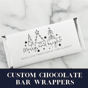 Może przedstawiać: Opakowanie białej tabliczki czekolady z czarno-białym wzorem choinek i gwiazd. Tekst "Merry and bright." jest napisany odręcznie. Tekst "Much love from Darcie, Toby & Stacy" jest również zawarty.