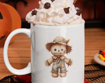 Puede incluir: Taza de cerámica blanca de 312 g con un diseño de espantapájaros. La taza está llena de crema batida, chispas de chocolate y una rama de canela. La taza está sobre un posavasos rojo con un tapete de encaje negro. Decoraciones de Halloween en el fondo.