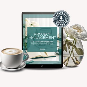 May include: A tablet displaying an ebook titled PROJECT MANAGEMENT A CLEAR STARTING POINT FOR FIRST-TIME PROJECT MANAGERS with an instant download badge, accompanied by a white coffee cup on a saucer and a glass vase containing white peonies.