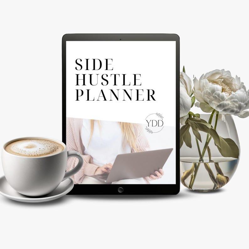 May include: A digital tablet displaying a side hustle planner with the text "SIDE HUSTLE PLANNER" and a logo that says "YDD". The tablet is sitting on a table next to a cup of coffee and a vase with white flowers.