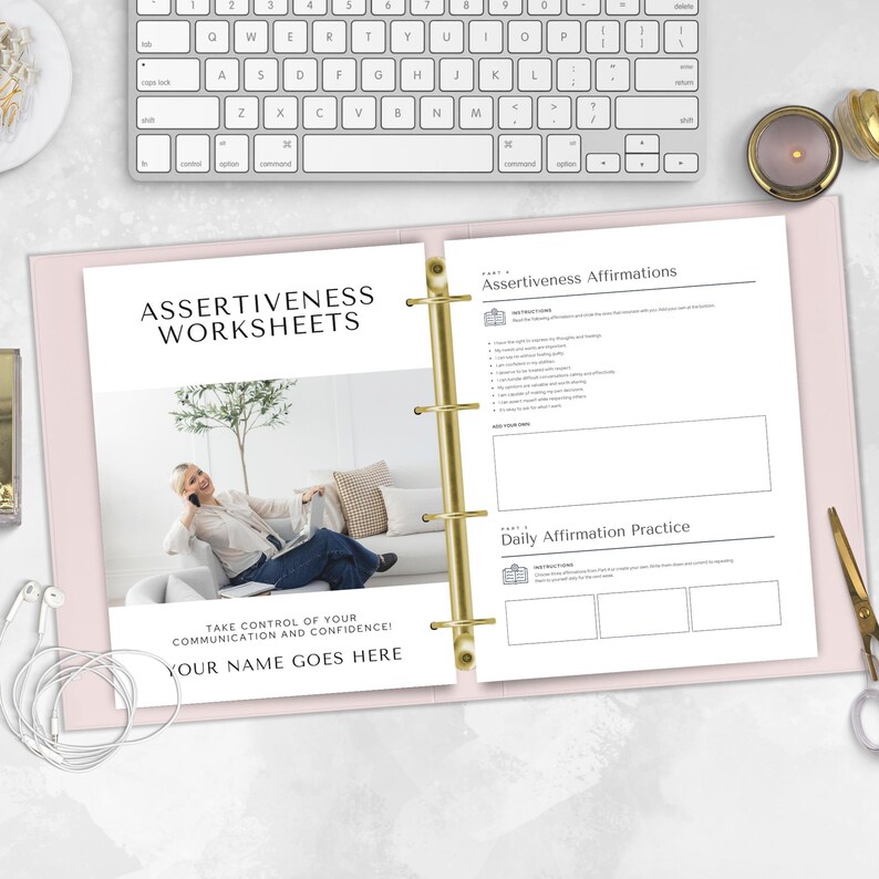 May include: A pink binder with gold rings, titled "Assertiveness Worksheets". The left page features a photo of a woman on a couch, with the text "Take control of your communication and confidence! Your name goes here". The right page has the title "Assertiveness Affirmations" and "Daily Affirmation Practice".