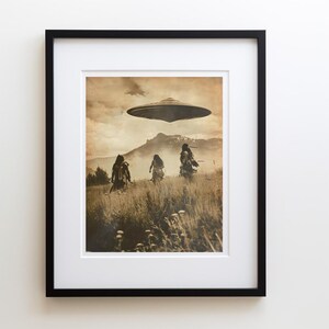 May include: Sepia-toned framed print featuring a UFO hovering over a field with three figures. The figures, silhouetted against the landscape, appear to be walking through tall grass. Mountains and clouds fill the background, creating a surreal, vintage aesthetic.