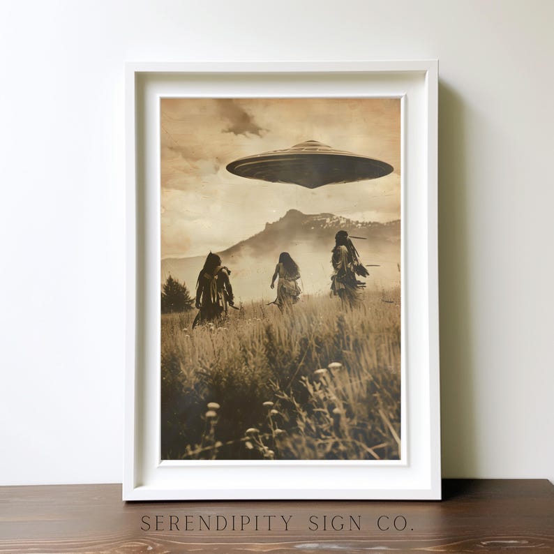 May include: Framed sepia-toned print featuring a vintage-style image of three figures walking through a field towards a hovering UFO. The print is in a white frame, with the text "SERENDIPITY SIGN CO." at the bottom.