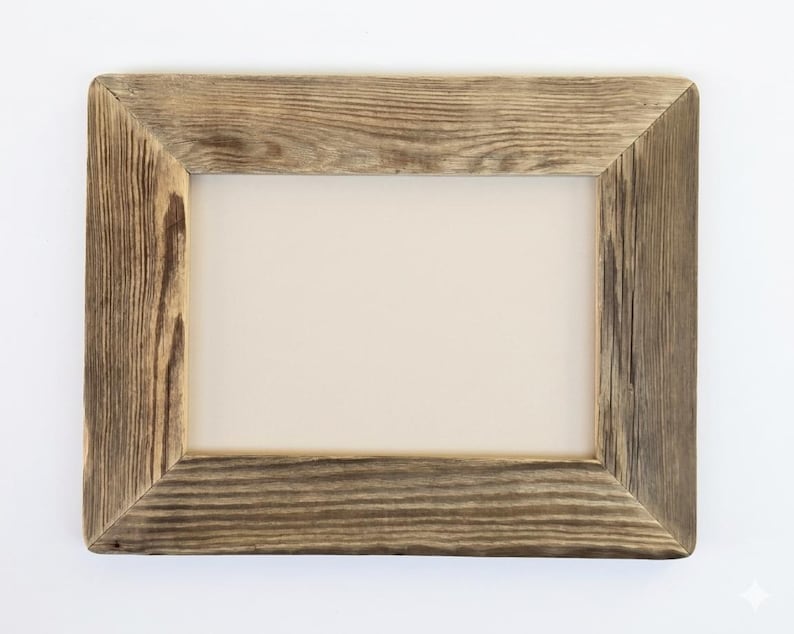 May include: A rectangular picture frame constructed from weathered brown wood with a visible grain pattern. The frame features mitered corners and a plain, light beige rectangular insert centered within the opening of the wooden border.