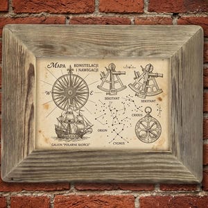May include: A framed print featuring a vintage-style nautical chart titled "MAPA KONSTELACJI i NAWIGACJI". The illustration includes a compass rose, a sailing ship labeled "GALION POLARNE SŁOŃCE", two sextants, and star constellations labeled Orion, Crious, and Cygnus.