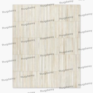 Könnte beinhalten: Ein rechteckiger Teppich mit hellem Holzmaserungsmuster. Der Teppich besteht aus vertikalen Holzplanken in verschiedenen Beige- und Cremetönen. Das Wort "Rugdaisy" ist wiederholt auf dem Teppich aufgedruckt.