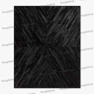 Könnte beinhalten: Ein rechteckiger schwarzer Teppich mit geometrischem Muster. Das Design des Teppichs zeigt eine Reihe dunkler, abgewinkelter Linien, die sich zur Mitte hin verjüngen und ein Zickzackmuster bilden. Der Teppich besteht aus einem dunklen Material.