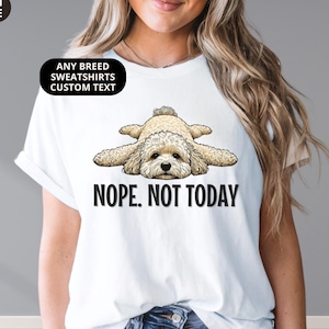 May include: White unisex tee with a light brown dog illustration and the text "Nope. Not Today." The tee also features the text "Premium Unisex Tee," "Any Breed Sweatshirts Custom Text," and "White."