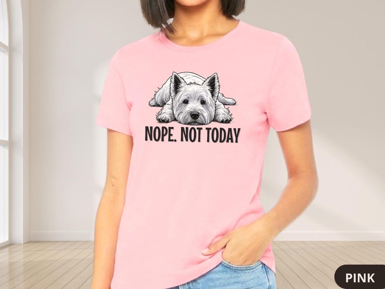 May include: A light pink t-shirt featuring a black and white illustration of a West Highland White Terrier dog lying down. The text "NOPE. NOT TODAY" is printed below the dog. The shirt is a solid color.