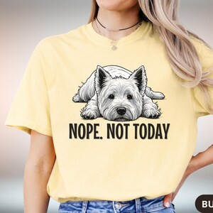 May include: Butter yellow t-shirt featuring a black and white illustration of a West Highland White Terrier dog lying down. The text "NOPE. NOT TODAY" is printed below the dog. The shirt is made of a soft material.