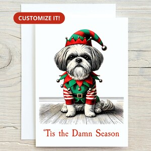 May include: A Christmas card featuring a Shih Tzu dog dressed as an elf. The dog wears a red and green elf costume and hat. The text "'Tis the Damn Season" is printed in red at the bottom of the card. The card is on a white background.