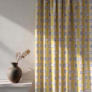 May include: Yellow and white striped curtain with a repeating pattern of blue fish. The curtain is hanging in front of a white wall. A brown vase with dried flowers sits on a white shelf.
