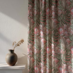 May include: A floral curtain with a repeating pattern of pink protea flowers and large green leaves against a muted pink background. A brown vase with dried stems sits on a white shelf to the left.