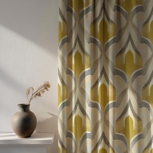 Puede incluir: Una cortina estampada con un diseño geométrico repetitivo en tonos amarillos, grises y beige. La cortina cuelga frente a una pared blanca. Un jarrón pequeño y oscuro con flores secas está sobre una repisa blanca.