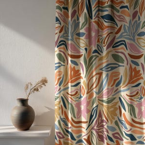 Könnte beinhalten: Cremefarbener Vorhang mit einem sich wiederholenden Muster aus stilisierten Blumen- und Blattformen in Orange, Blau, Rosa und Grün. Das Design hat eine moderne, abstrakte Ausstrahlung, geeignet für die Inneneinrichtung.