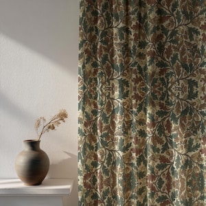 May include: Curtains with a repeating pattern of oak leaves and acorns in green, brown, and beige. The fabric is draped, creating soft folds. A ceramic vase with dried stems sits on a white shelf.