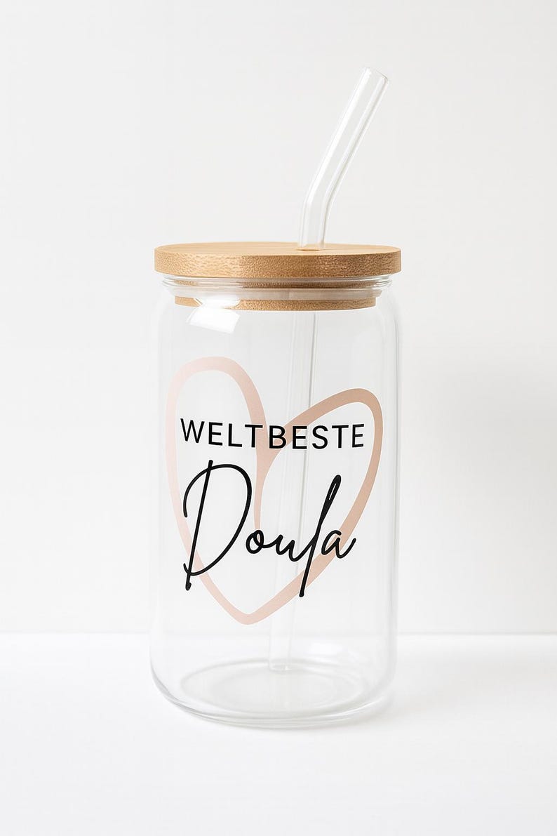 May include: A clear glass tumbler with a bamboo lid and a glass straw. The front features a light pink heart outline with the black text WELTBESTE and the word Doula written in a cursive script font centered within the heart shape.