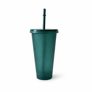 Puede incluir: Un vaso de color verde bosque oscuro con tapa a juego y una pajita vertical. La taza presenta un acabado sutil de purpurina fina en toda su superficie, estrech&aacute;ndose ligeramente desde el borde ancho hasta una base circular plana.