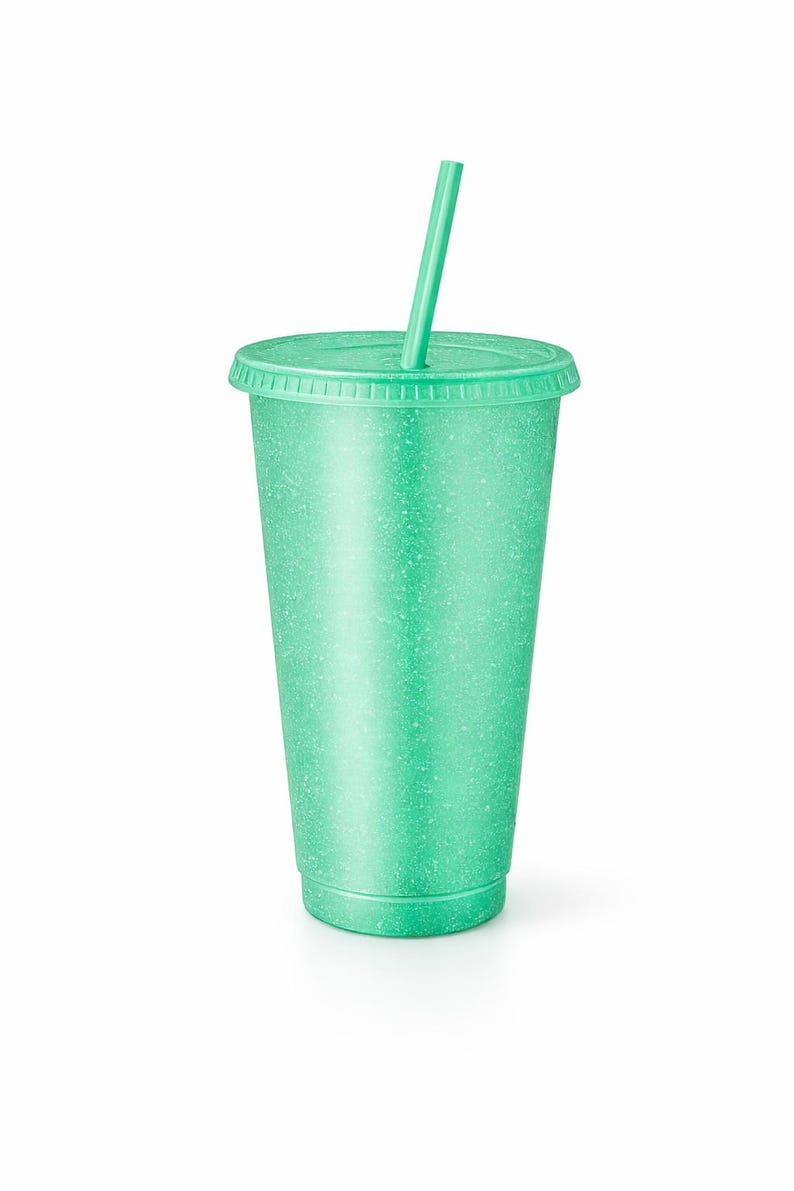 Puede incluir: Un vaso reutilizable de color verde menta con textura moteada, que incluye una tapa a juego y una pajita recta insertada en el centro. El vaso tiene una forma cil&iacute;ndrica c&oacute;nica con un borde estriado y un color uniforme y constante.