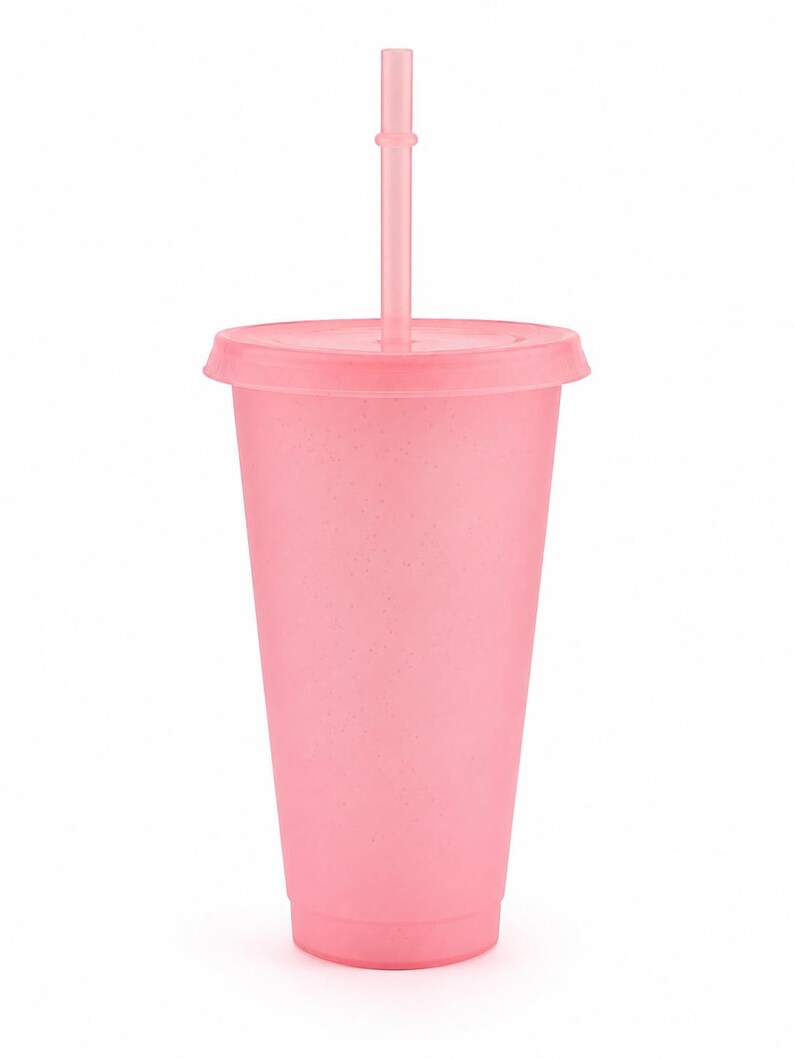 Puede incluir: Un vaso de color rosa claro con un acabado mate y moteado, que incluye una tapa a juego y una pajita recta insertada en el centro. El vaso tiene una forma cil&iacute;ndrica c&oacute;nica con una base plana y un borde ancho, de un color pastel uniforme.