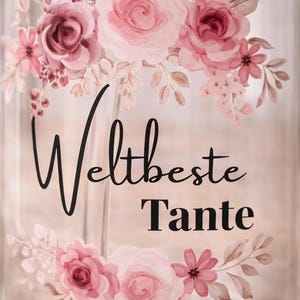 Może przedstawiać: Przezroczysta szklanka z kwiatowym wzorem przedstawiającym r&oacute;żowe r&oacute;że i liście. Tekst "Weltbeste Tante" jest nadrukowany czarną czcionką, łączącą pismo odręczne z bezszeryfową, pomiędzy kwiatowymi motywami na gładkiej, cylindrycznej powierzchni.