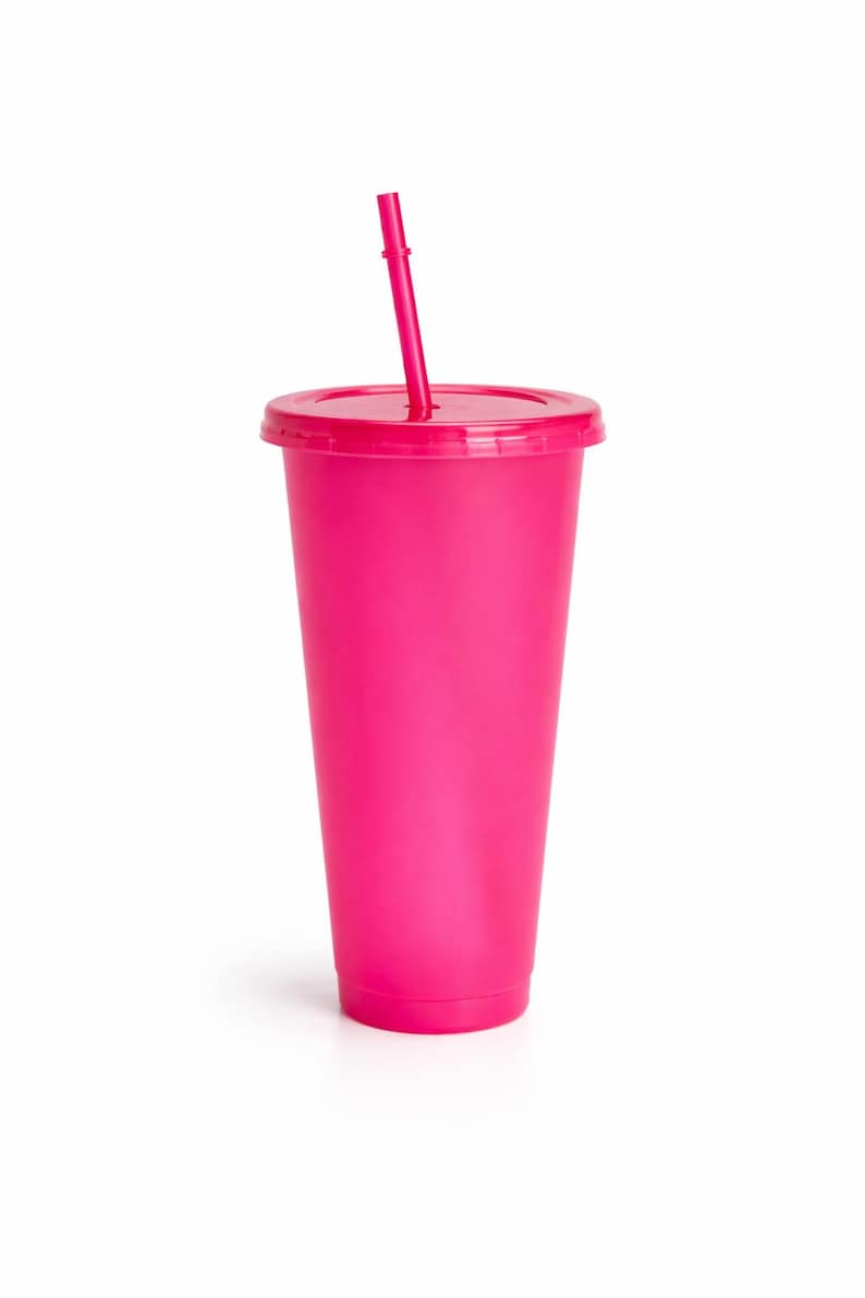 Puede incluir: Un vaso de color rosa intenso con tapa a juego y pajita reutilizable. El vaso presenta un exterior liso de color s&oacute;lido con una forma cil&iacute;ndrica c&oacute;nica, dise&ntilde;ado para contener bebidas fr&iacute;as manteniendo un tono brillante y uniforme.