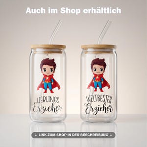 May include: Two clear glass tumblers with bamboo lids and glass straws. Each features a cartoon superhero illustration and black text. The left glass reads "LIEBLINGS Erzieher" and the right glass reads "WELTBESTER Erzieher". The text "Auch im Shop erh&auml;ltlich" appears at the top.