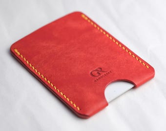 May include: Red leather card holder with yellow stitching and the text "GR HANDCRAFT" embossed on the front.